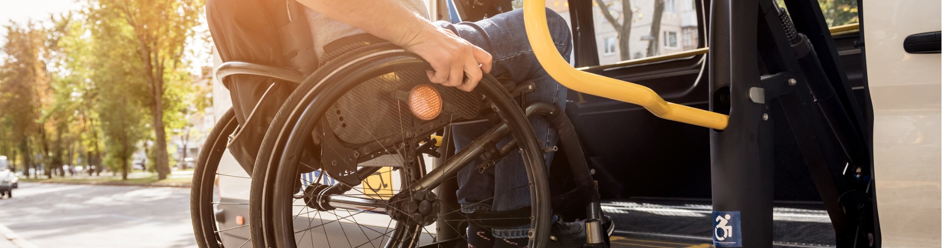 a-man-in-a-wheelchair-on-a-lift-of-a-vehicle-for-people-with-disabilities 1900x500