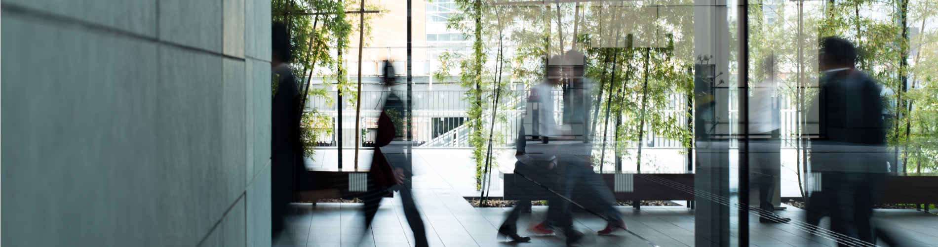 business-person-walking-in-a-urban-building 1900x500