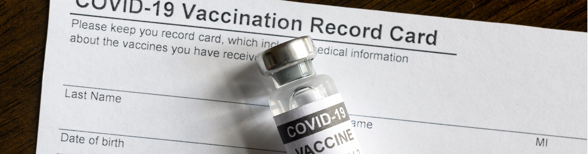 covid-19-vaccine-bottle-on-coronavirus-vaccination-record-card 1900x500