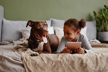 girl-with-dog-on-bed-picture-360x240