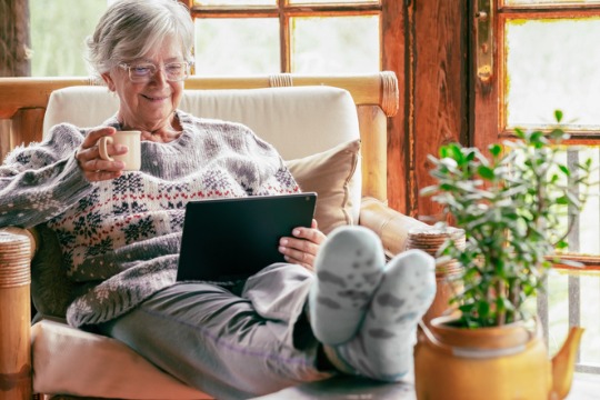 old-senior-woman-sitting-at-home-on-armchair-using-digital-tablet-wearing-a-warm-sweater-and540x360.jpg