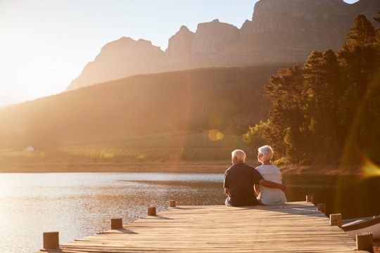 romantic-senior-couple-sitting-on-wooden-jetty-by-lake-540x360