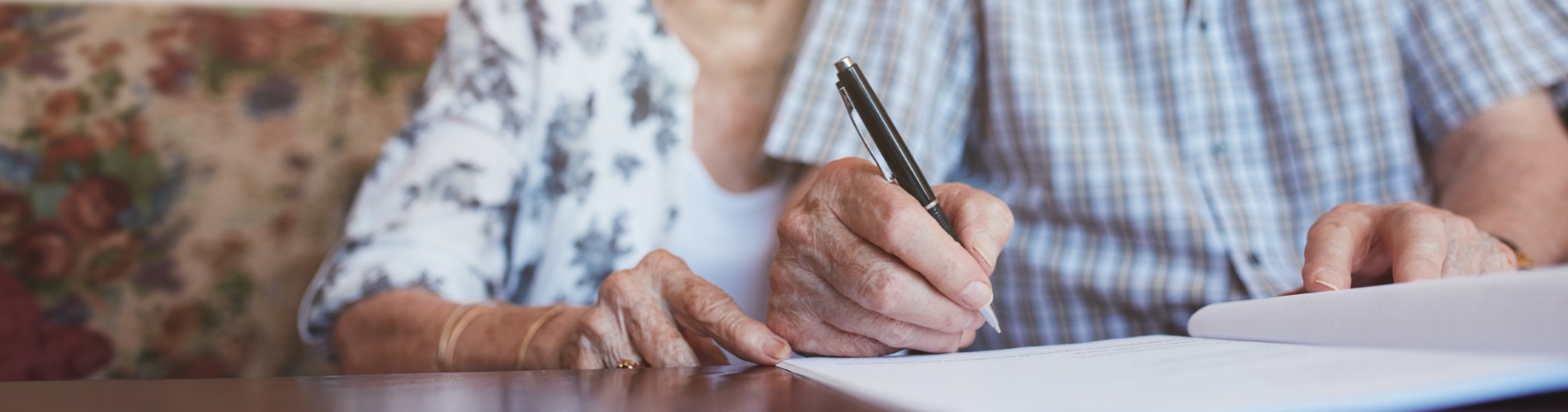 senior-couple-signing-documents-1900x500