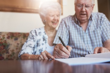senior-couple-signing-documents-360x240