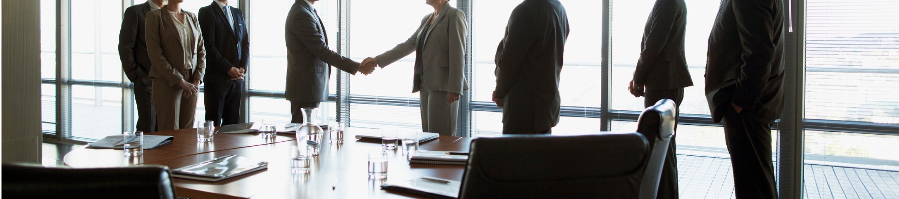 business-people-shaking-hands-in-conference-room 1800x400