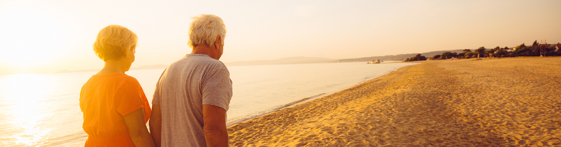 retirement couple on beach - web banner