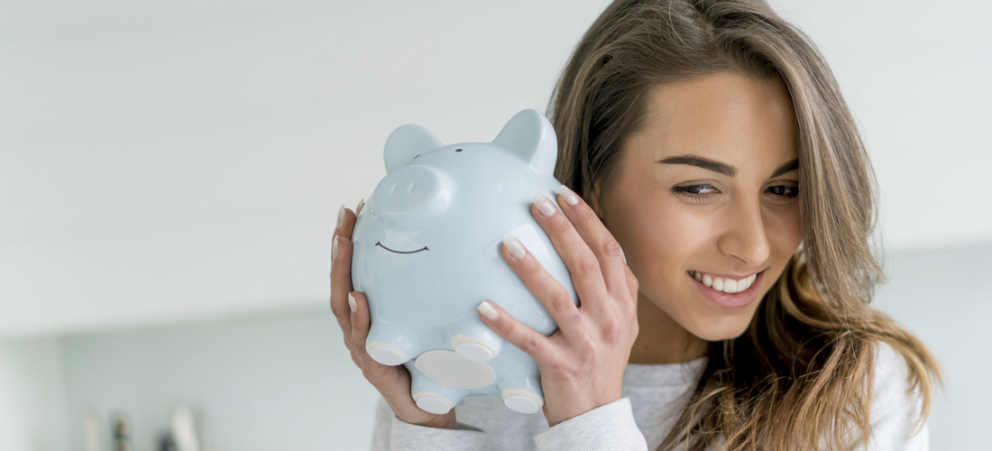 Woman shaking piggy bank - money management 1100x500