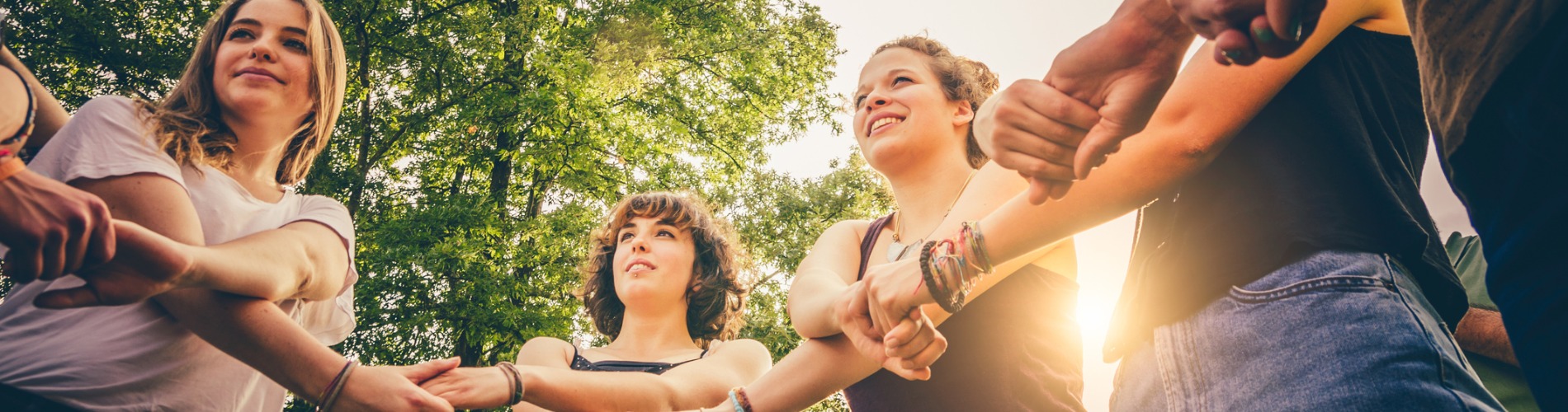 friends-holding-hands-in-the-park-1900x500